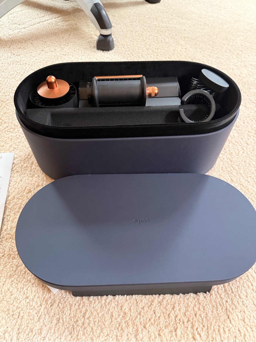 Dyson navy blue accessory case with copper-accented attachments